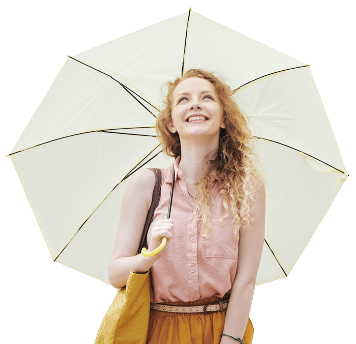 Woman stands beneath an open white umbrella and smiles.