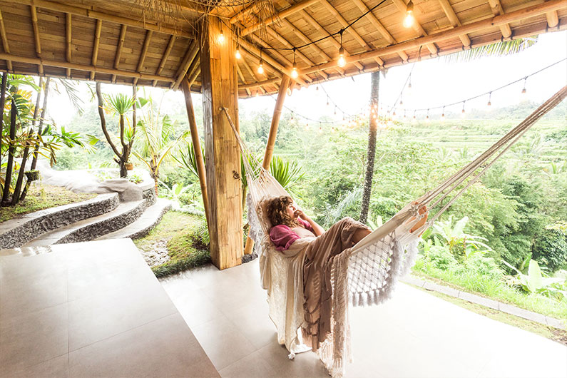 Woman laying in hammock enjoying nature view