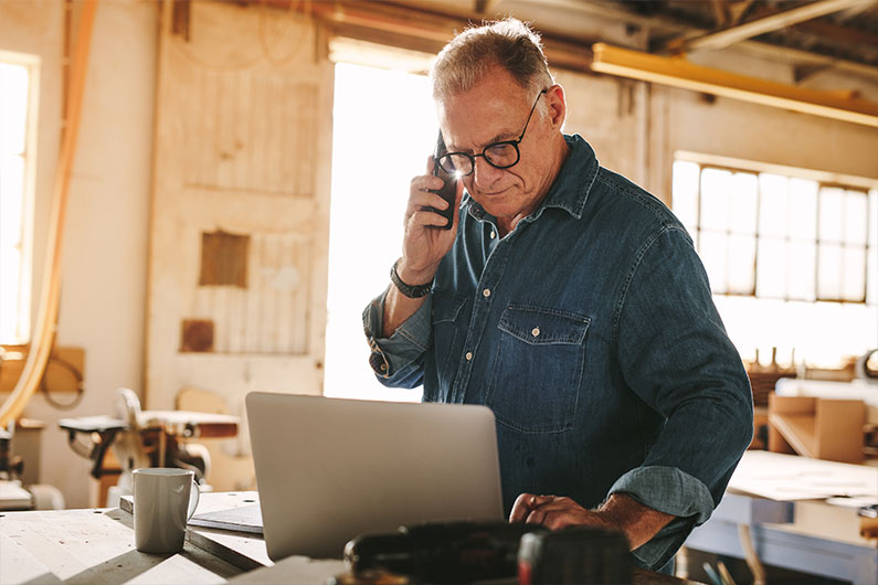 Older man on phone and laptop