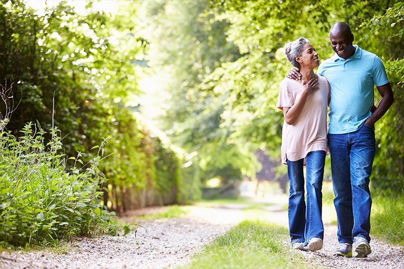 Older couple walking down path in the woods