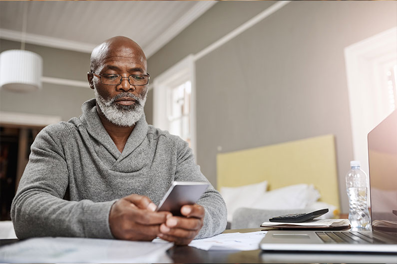 Older man on cell phone reading