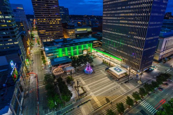 An aerial shot of Fifth Third Bank and Cincinnati's Fountain Square glowing green. 