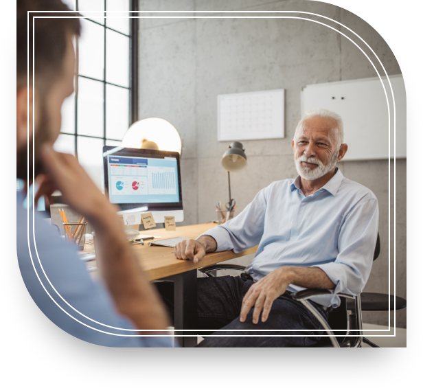 An older man in front of a computer talks to a younger man about equity compensation concentration risk.  