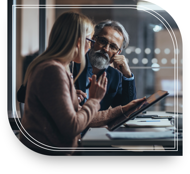 A man and woman sit in front of a tablet discussing lending solutions.