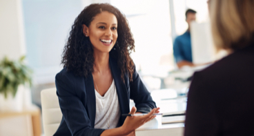 Two women in a meeting discussing escrow agent services.