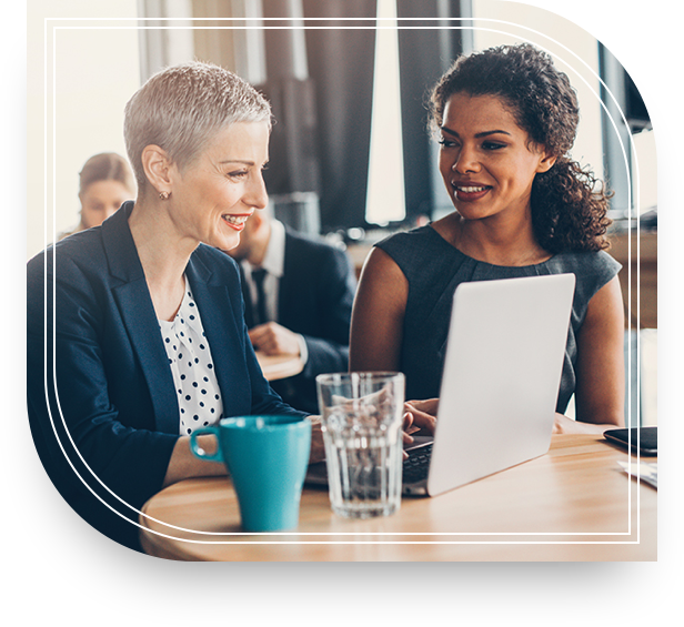 Two women with a laptop discussing wealth management. 