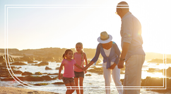 Retired couple and grandkids on a beach after working with Fifth Third for their wealth management solutions.  