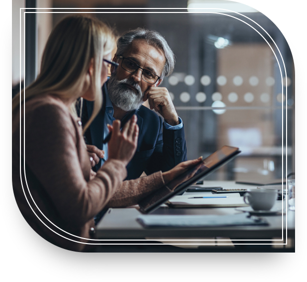 Man and woman talk about investments while looking at a tablet.