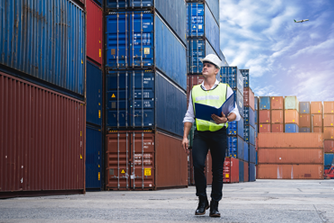 man walking by shipping container